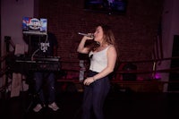 a woman singing into a microphone in front of a boxing ring